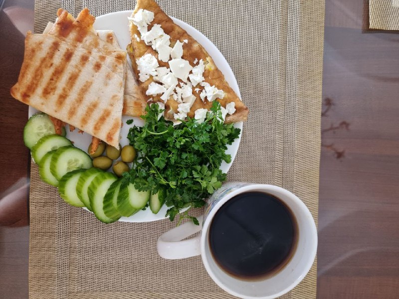Breakfast Platter With Omelet, Flatbread, Feta Cheese, Cucumber, Olives, Parsley, And Coffee