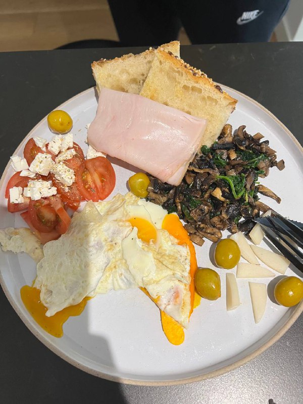 Breakfast Plate With Fried Eggs, Toast, Turkey Ham, Tomatoes With Feta, Sautéed Mushrooms With Spinach, Cheese, And Olives