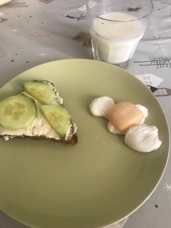 Light Breakfast Or Snack Plate Consisting Of An Open-faced Cucumber Sandwich With Cream Cheese And A Side Of Two Poached Eggs, Accompanied By A Glass Of Milk