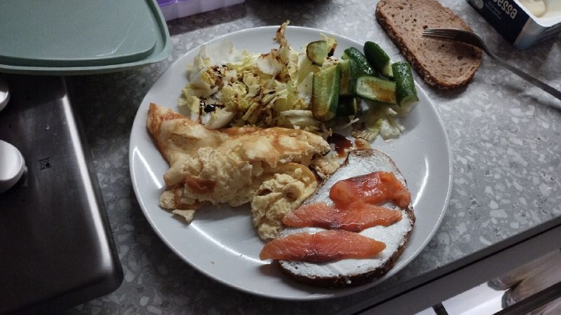 Home-cooked Meal With Scrambled Eggs, Smoked Salmon On Bread, Roasted Or Sautéed Cabbage, And Possibly Sautéed Zucchini