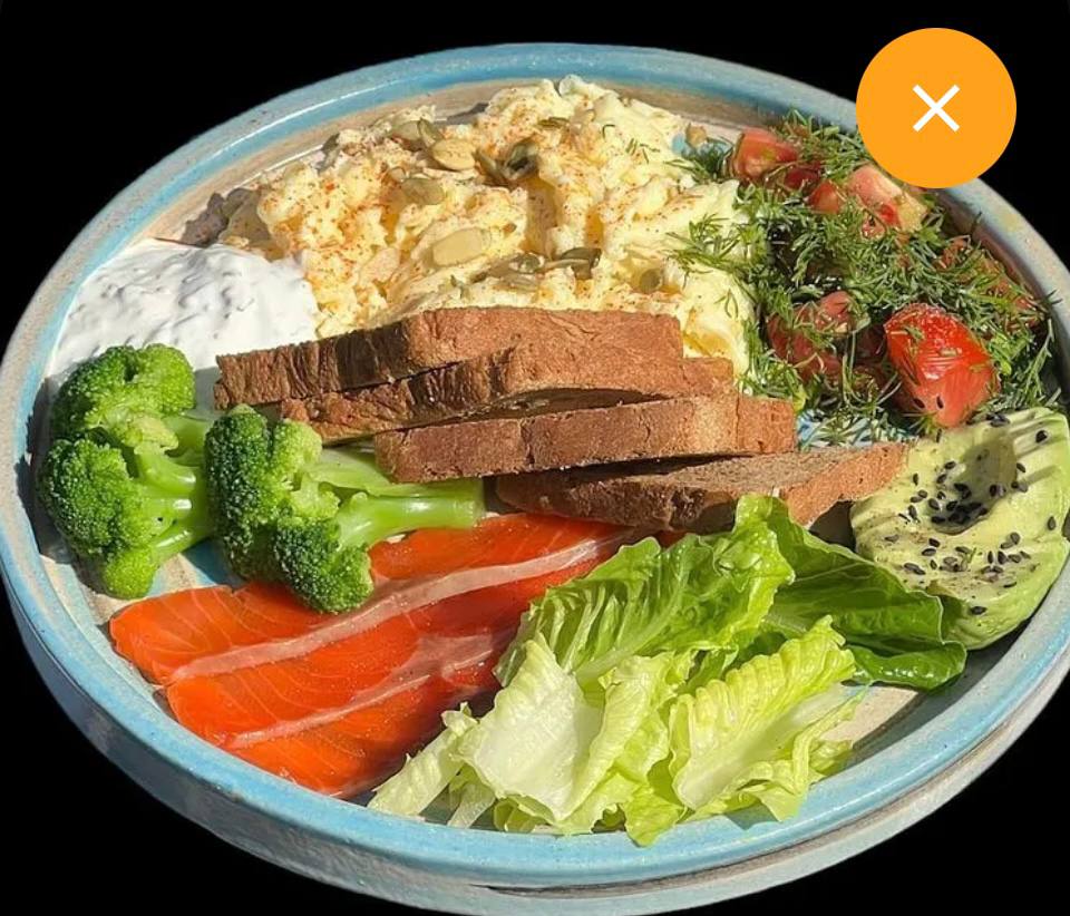 Variety Plate With Smoked Salmon, Scrambled Eggs, Vegetables, Bread, And Side Of Cream Or Dip