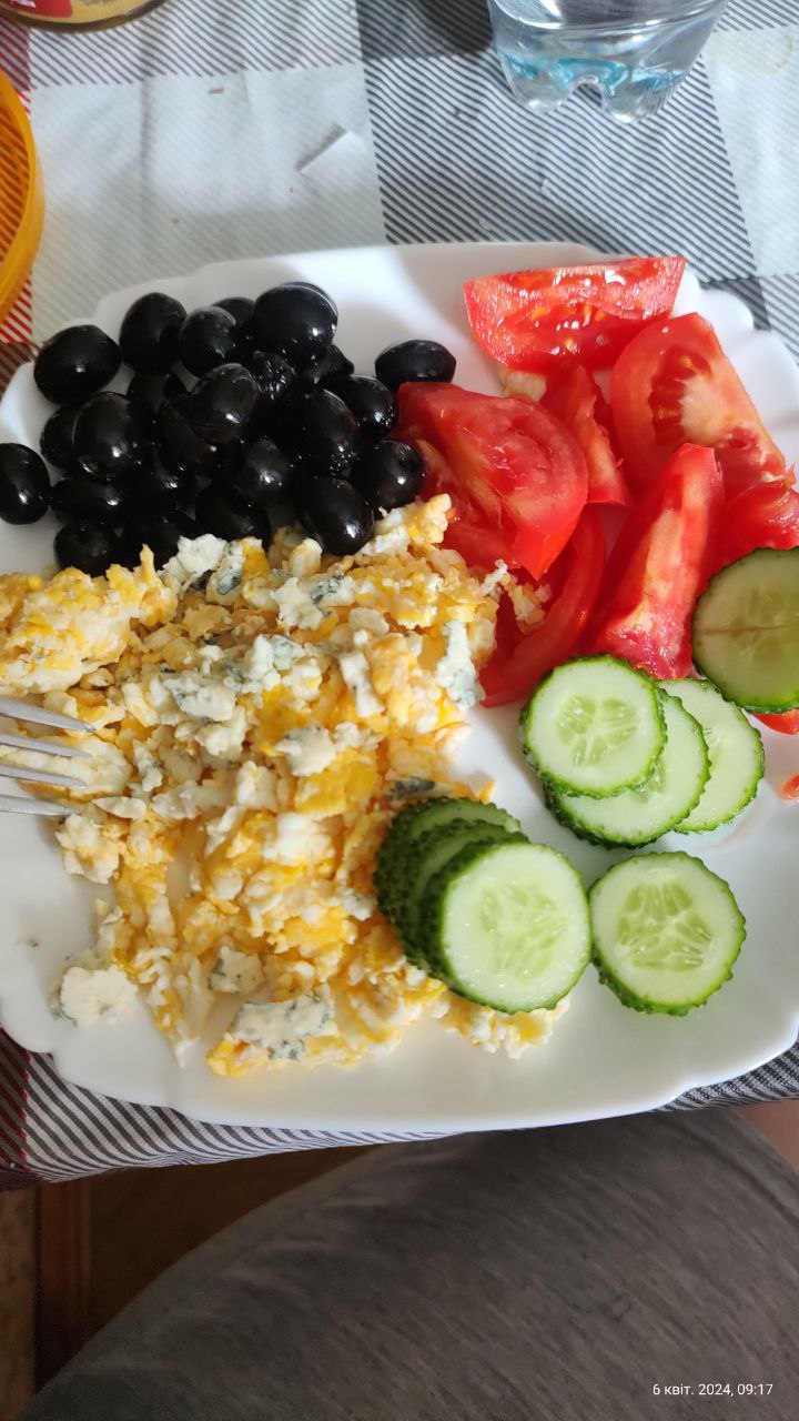 Scrambled Eggs With Cheese, Black Olives, Tomatoes, And Cucumber Slices