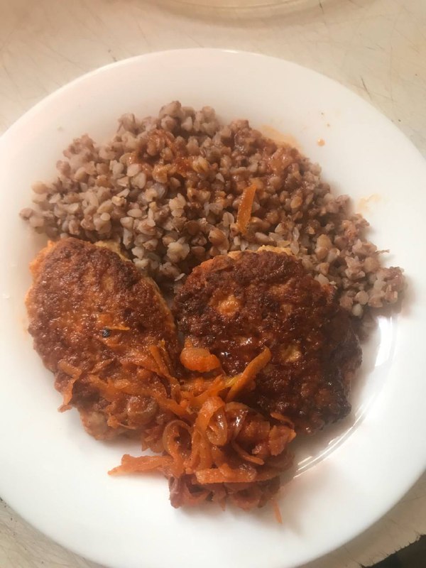 Dish Comprised Of Buckwheat Kasha As A Side And Meat Patties With Tomato Sauce On Top