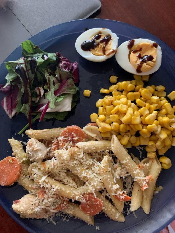 Composed Plate With Penne Pasta, Chicken, Parmesan Cheese, Mixed Salad Greens, Corn, Hard-boiled Egg, And Balsamic Glaze